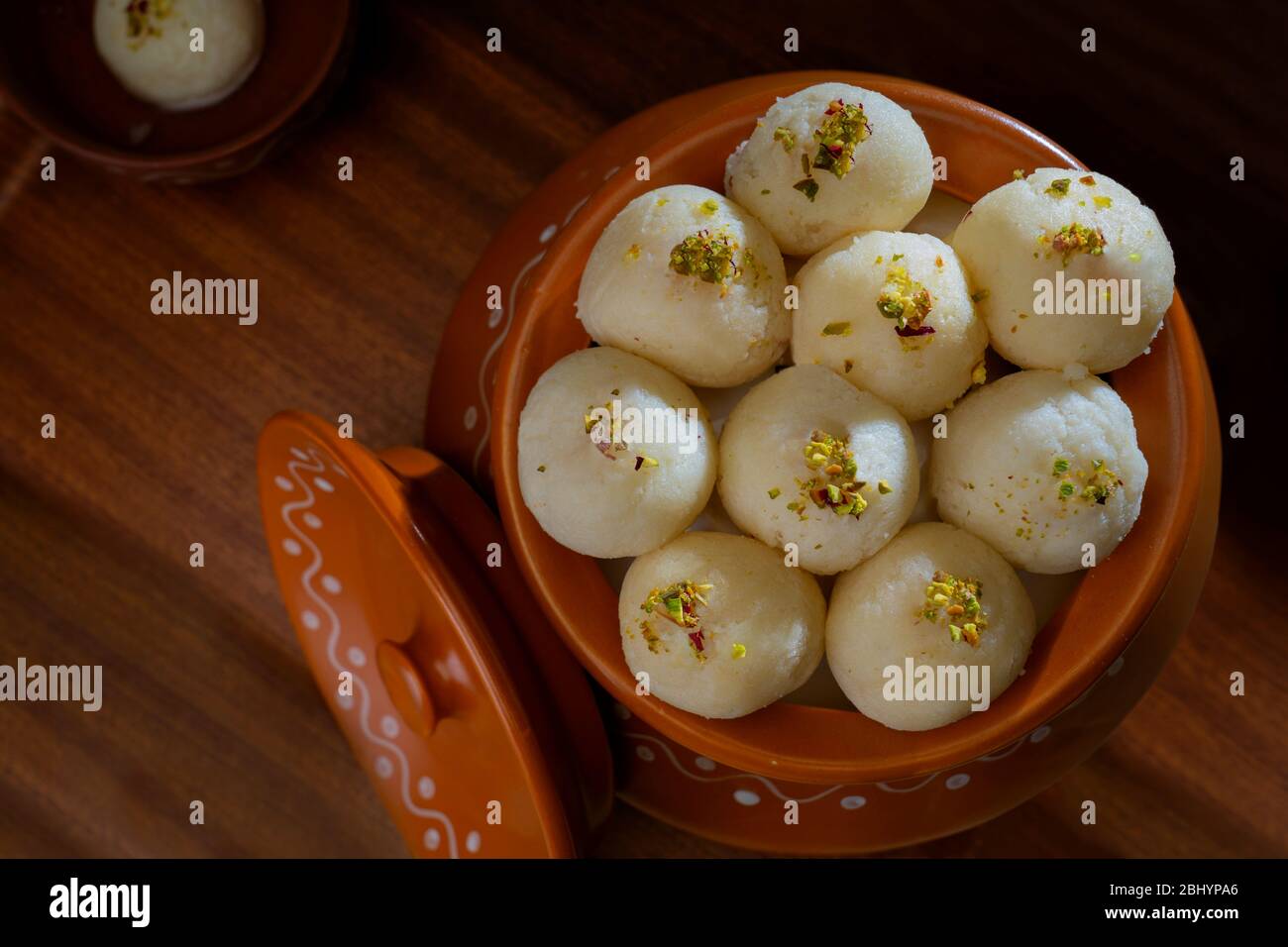 Rasgullas bianco conservato in un handi con pistacchi spruzzati. Foto Stock