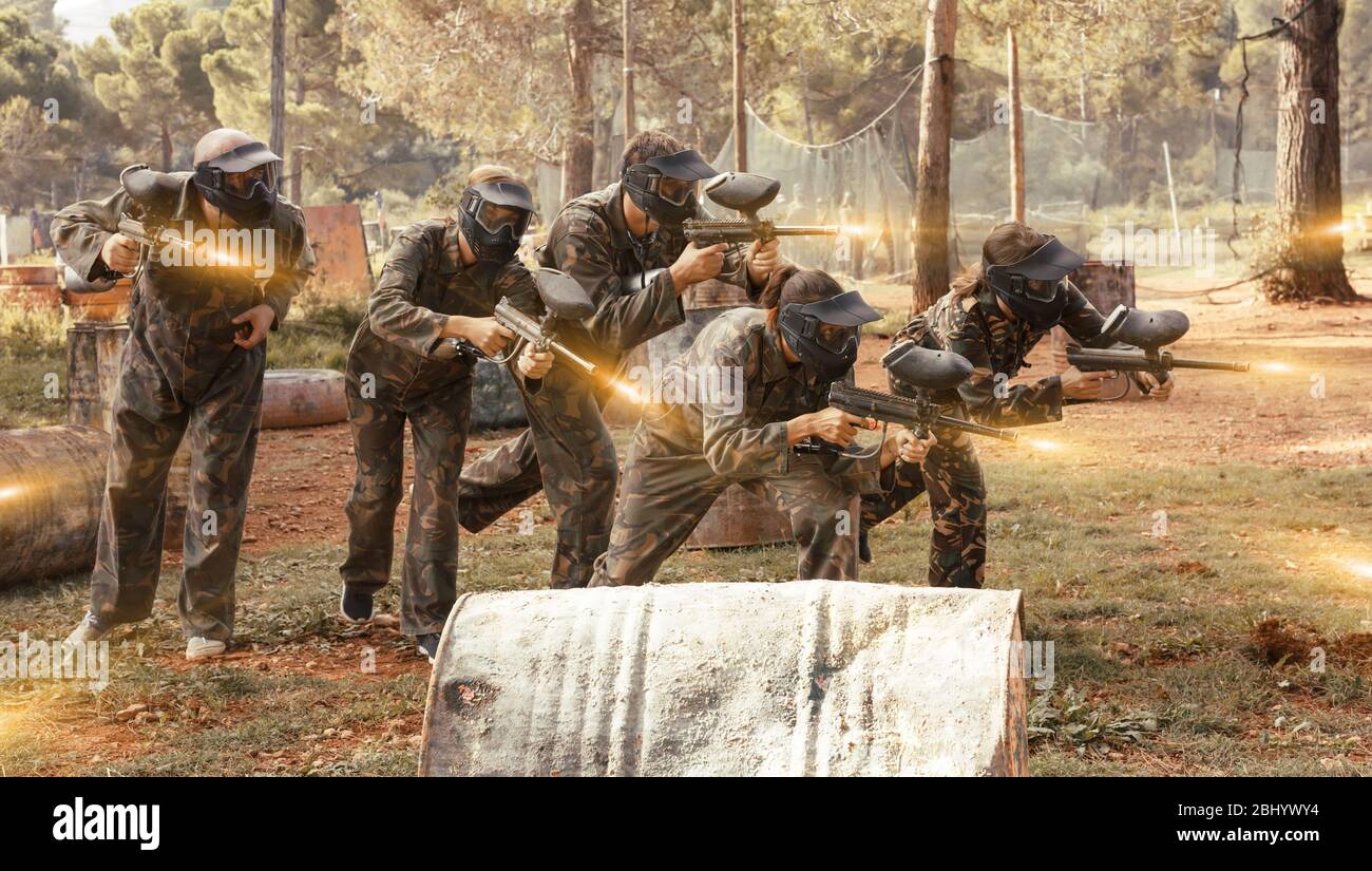 Dynamic paintball battaglia all'esterno. Un gruppo di persone in piena attrezzatura paintball attaccando squadra opposta Foto Stock