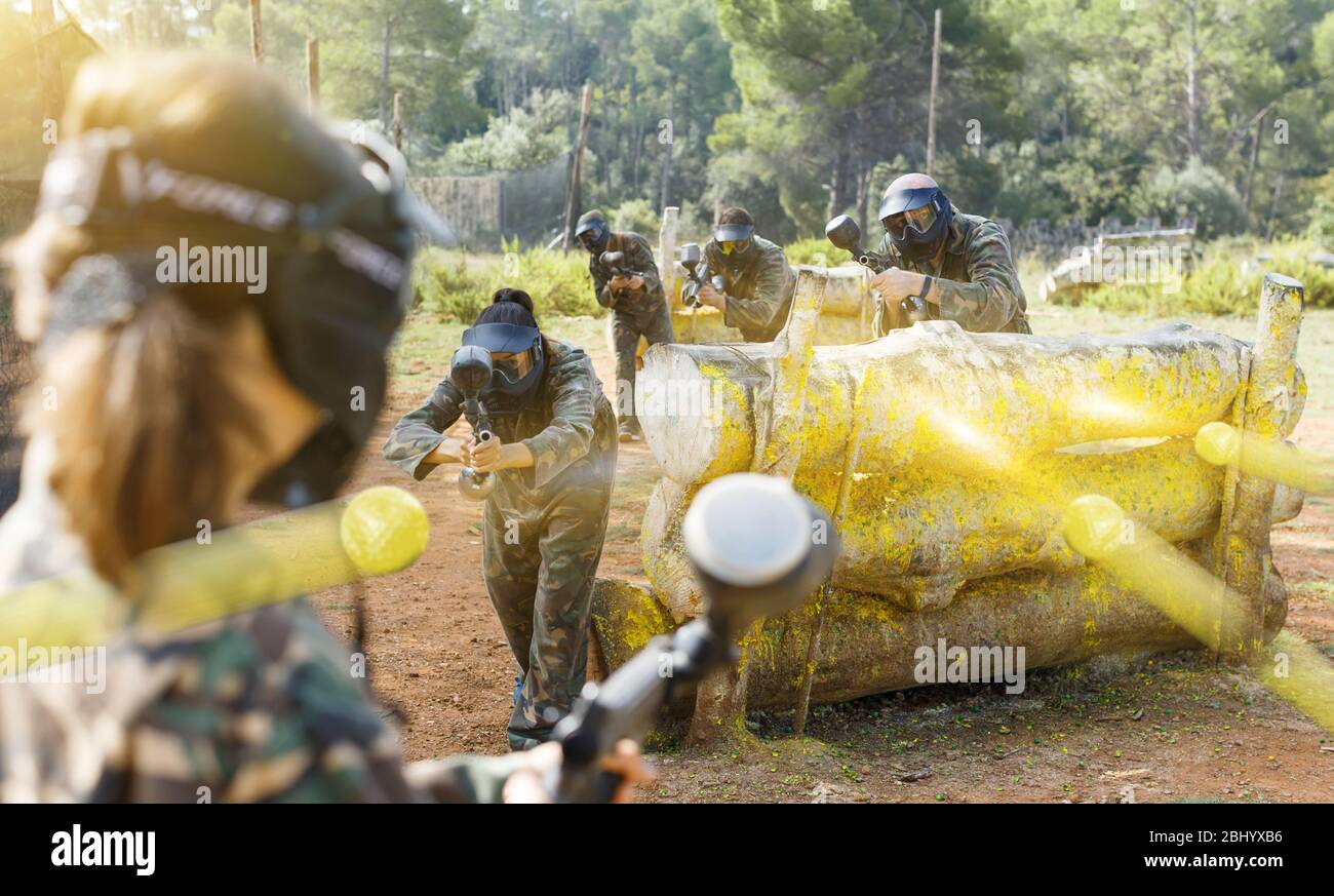 Gruppo di fronte ai giocatori di paintball in camuffamento con pistole a giocare in battaglia nella foresta all'aperto Foto Stock