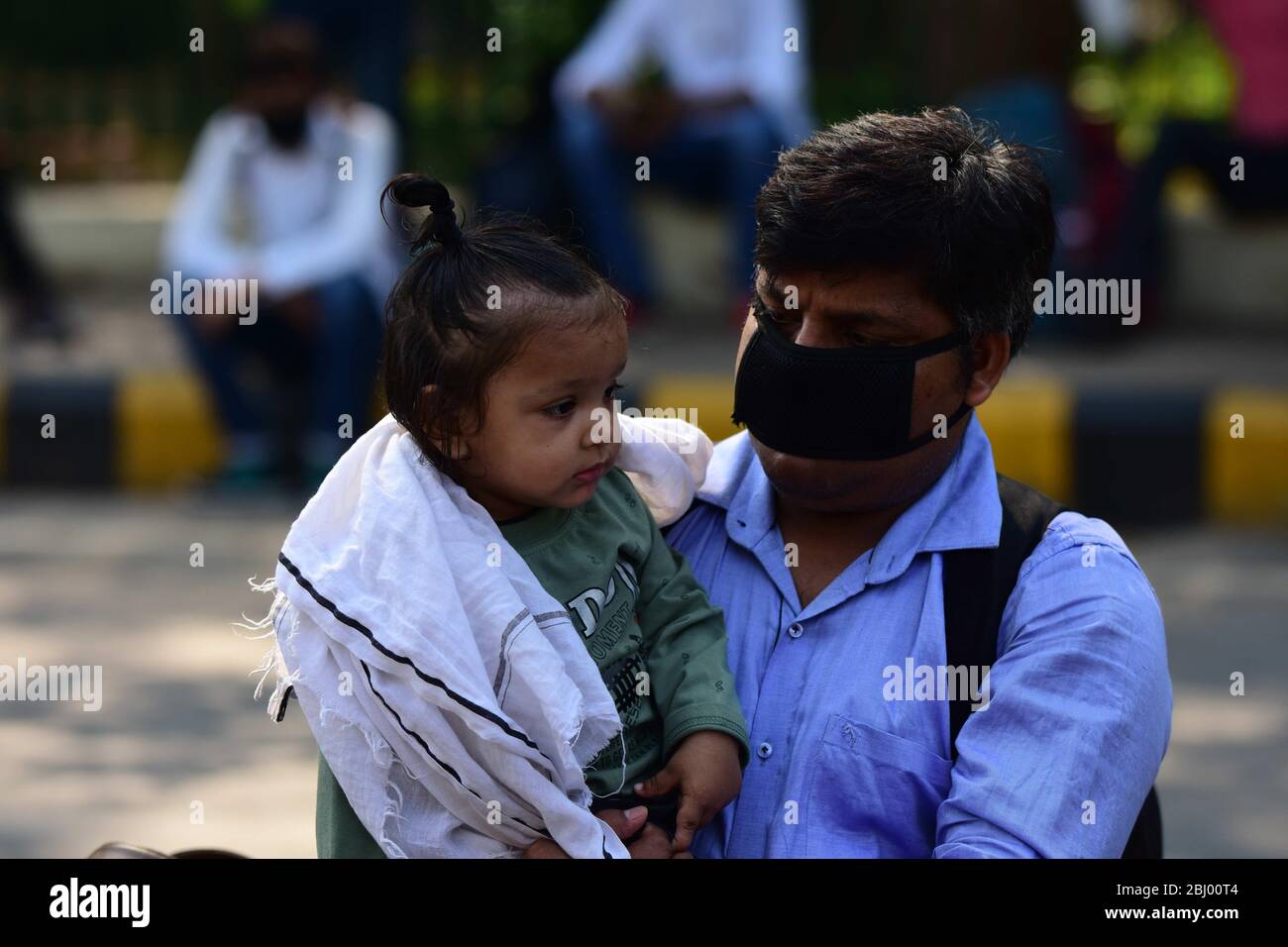 Prayagraj, India. 28 Aprile 2020. Uno studente bloccato con il suo bambino aspettare per l'autobus come il governo Uttar Pradesh ha organizzato autobus strade per inviare gli studenti alla loro città natale durante il governo ha imposto blocco a livello nazionale come misura preventiva contro il COVID-19 a Prayagraj. (Foto di Prabhat Kumar Verma/Pacific Press) Credit: Pacific Press Agency/Alamy Live News Foto Stock