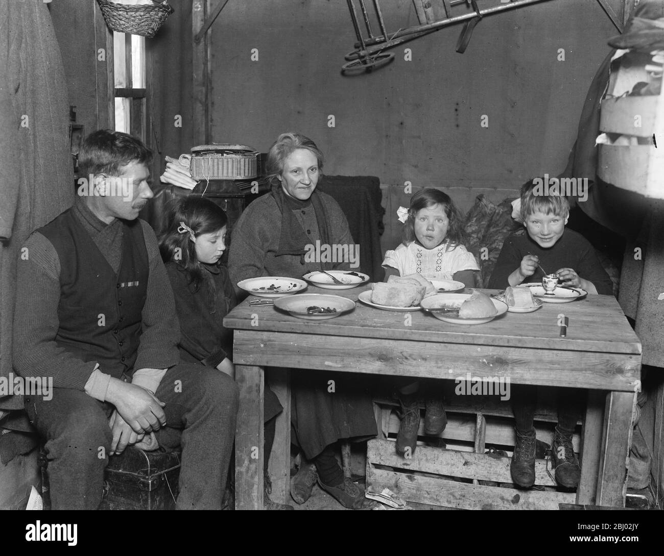 Ex famiglia soldato in capanna di tela a Greensted ( Essex ) - Hilder sua moglie e i figli ( Vivian , Victor e Audrey ) che hanno un pasto a casa - 28 gennaio 1920 Foto Stock
