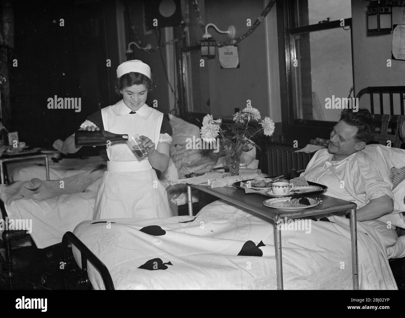 I pazienti ricevono un regalo di Natale , un bicchiere di birra , al Livingstone Hospital di Dartford . - 1937 Foto Stock