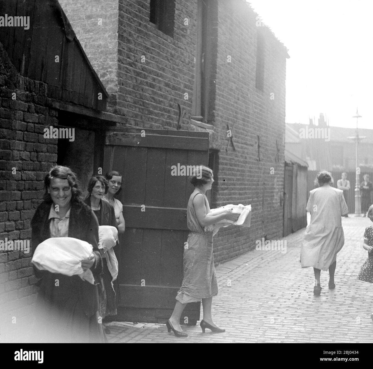 Cene di cucina presso i forni comunali nell'East End di Londra. - 1933 - Foto Stock