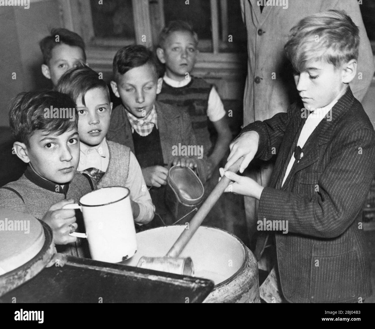 Germania del dopoguerra. 1947 ottobre - i ragazzi della scuola pubblica affamati di Monaco di Baviera di 11 e 12 anni si allineano per ricevere le razioni del cibo all'ora di pranzo. Foto Stock