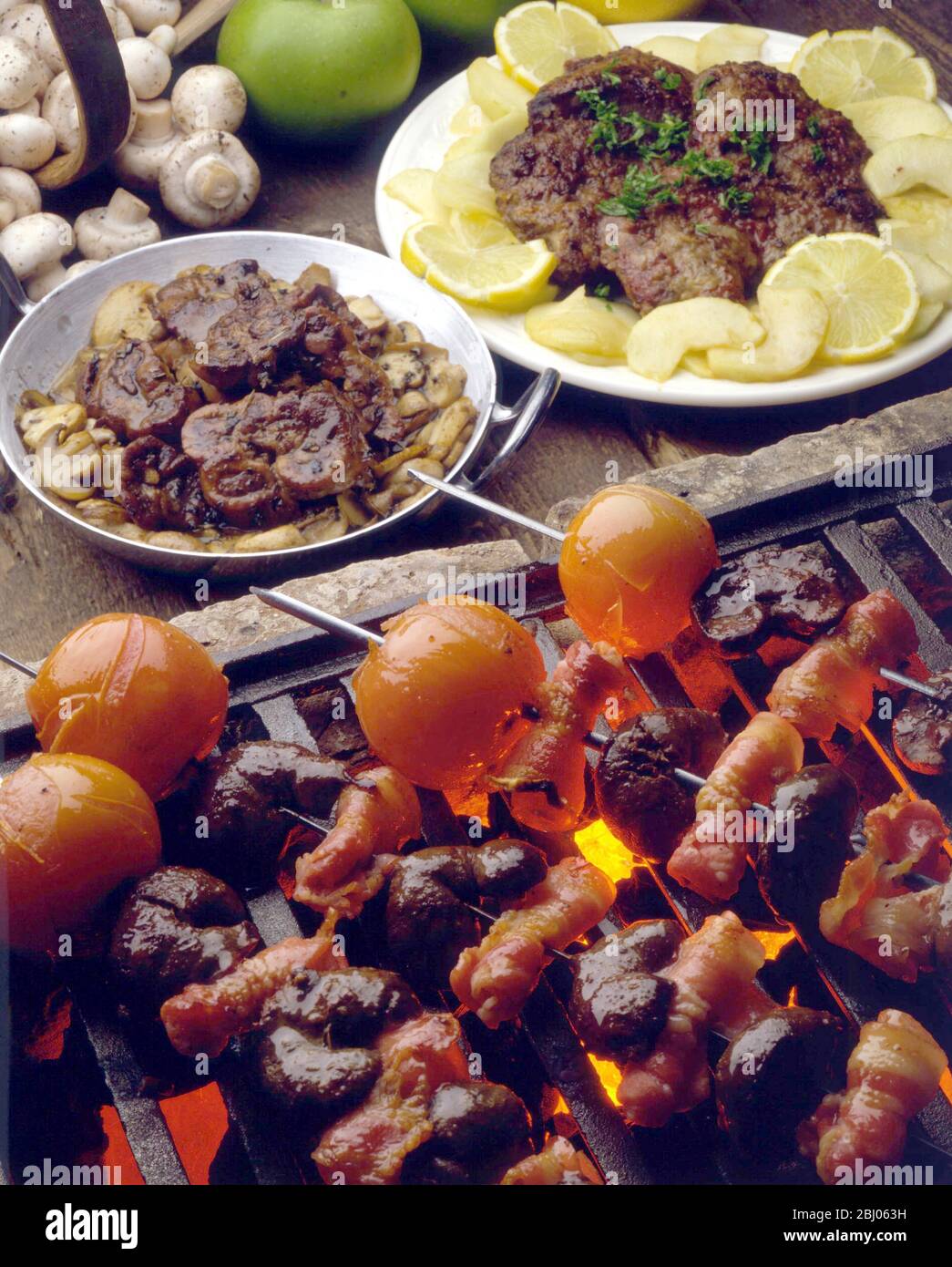 Kebab con rognoni, panini di bacino e pomodori alla griglia, con agnello alla griglia con fette di limone e. Foto Stock