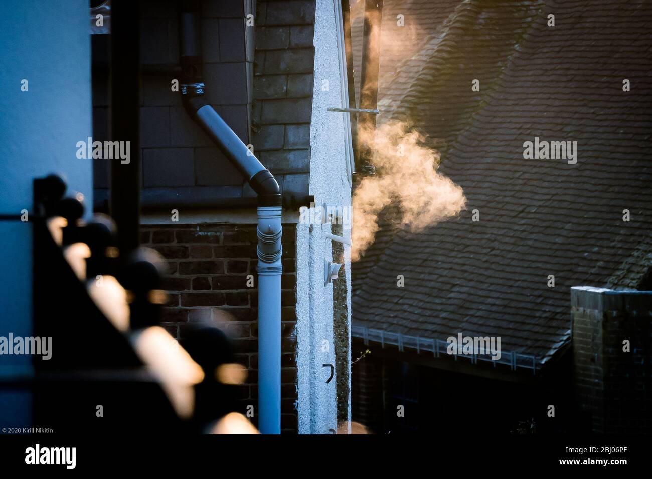 Regno Unito - il vapore esce dal tubo di ventilazione della caldaia di riscaldamento centrale in una vecchia casa in Inghilterra in una giornata fredda Foto Stock