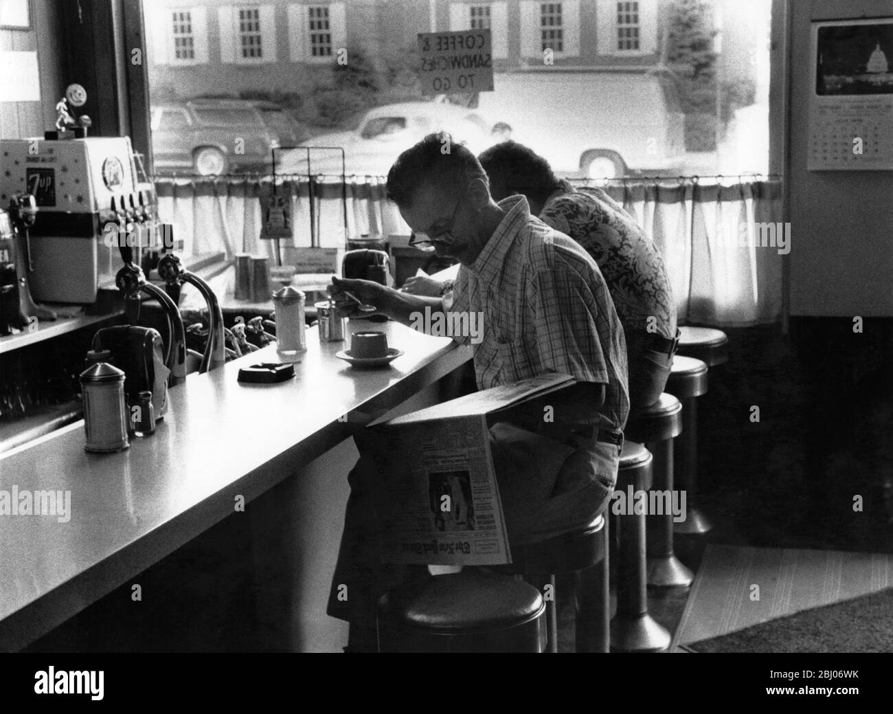 Uomo che ha un caffè e che legge il giornale del mattino in un caffè - Westwood , New Jersey Foto Stock