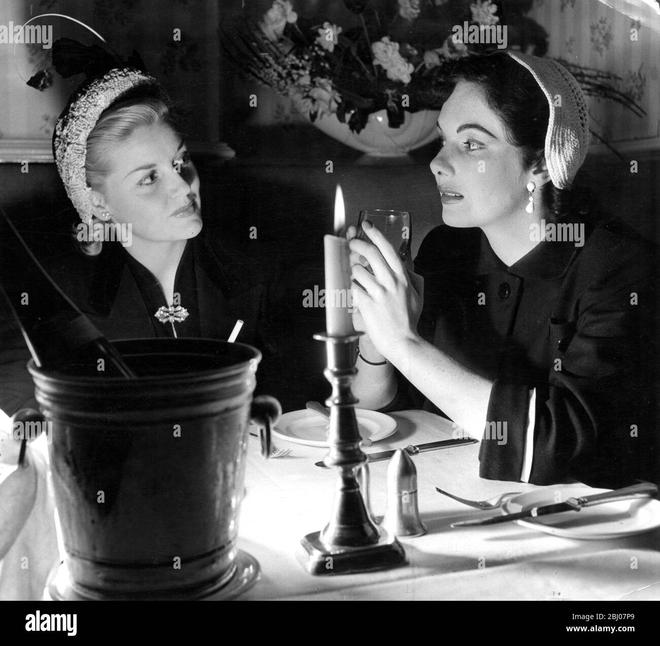 Betty Whelan (a sinistra) e Dorothy Flynn , giovani bellezze irlandesi che cenano a lume di candela in un ristorante locale , Irlanda . - 30 giugno 1951 Foto Stock