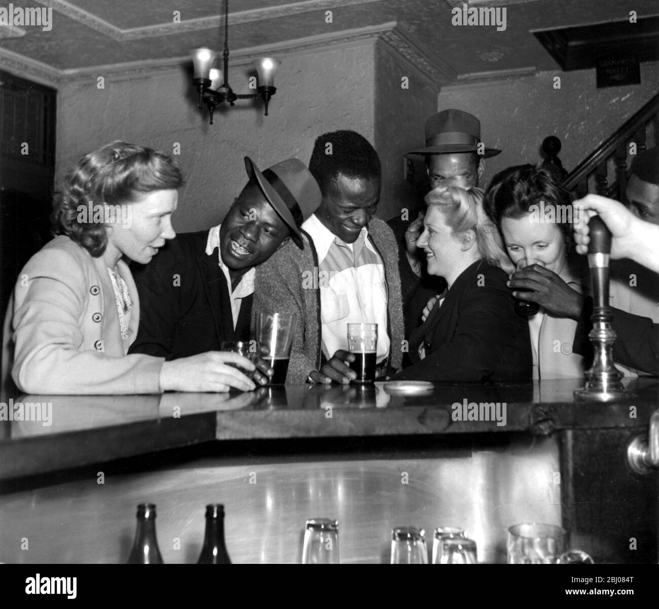 Scene nella casa pubblica 'Roebuck' Tottenham Court Road. Il pub è conosciuto come Jungle Arms. Il pubblico incoraggia il patrocinio di clienti africani e giamaicani - Settembre 1949 - didascalia originale Foto Stock