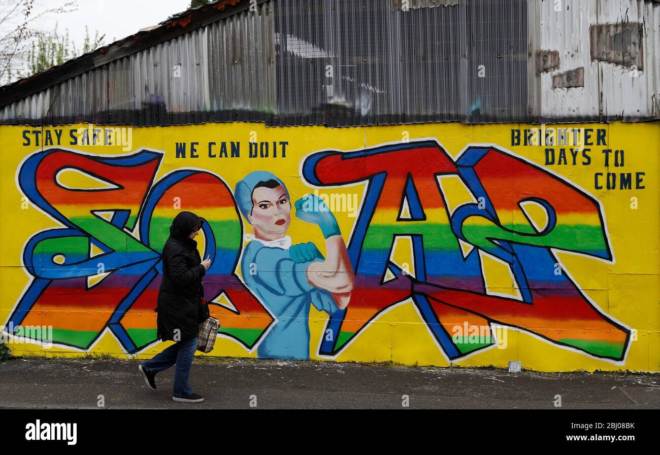 Derby, Derbyshire, Regno Unito. 28 aprile 2020. Una donna cammina oltre Covid-19 correlato Street art durante il blocco pandemico coronavirus. Credit Darren Staples/Alamy Live News. Foto Stock