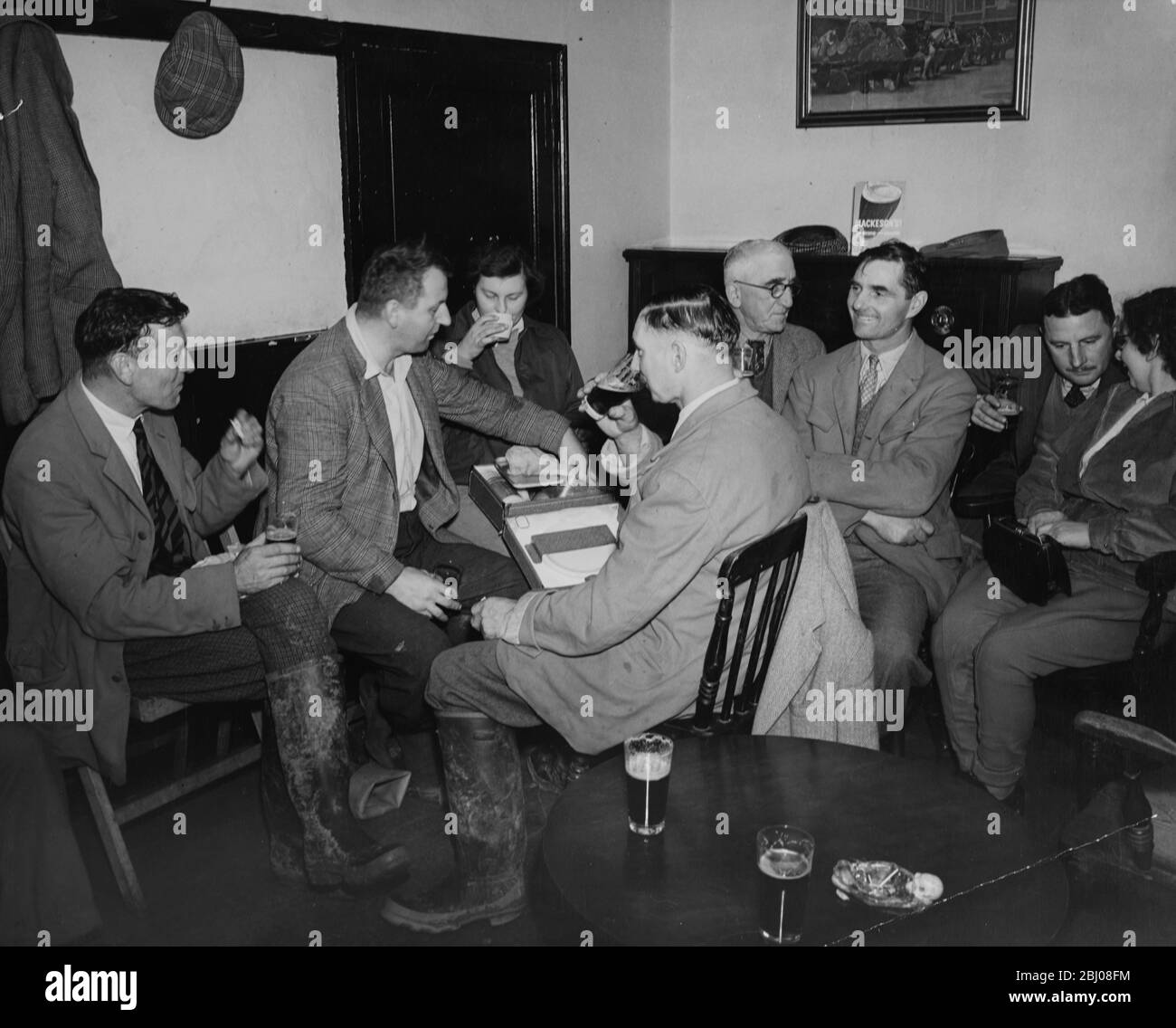 Il John Jones Coursing Club si incontra allo Star pub per bere birra e bere qualcosa mentre discute del lavoro della giornata e organizzando il prossimo incontro il giorno di Santo Stefano. - nella foto: Sig. J. Carey (Slipper); sig. J. Hilder; sig. B. Uden (Vice Field Master); H.P. Collick (Field Master) ; L. Uden (Slipper) ; W. McGaughey e la signora M. Jones. - 26 novembre 1953 - Foto Stock