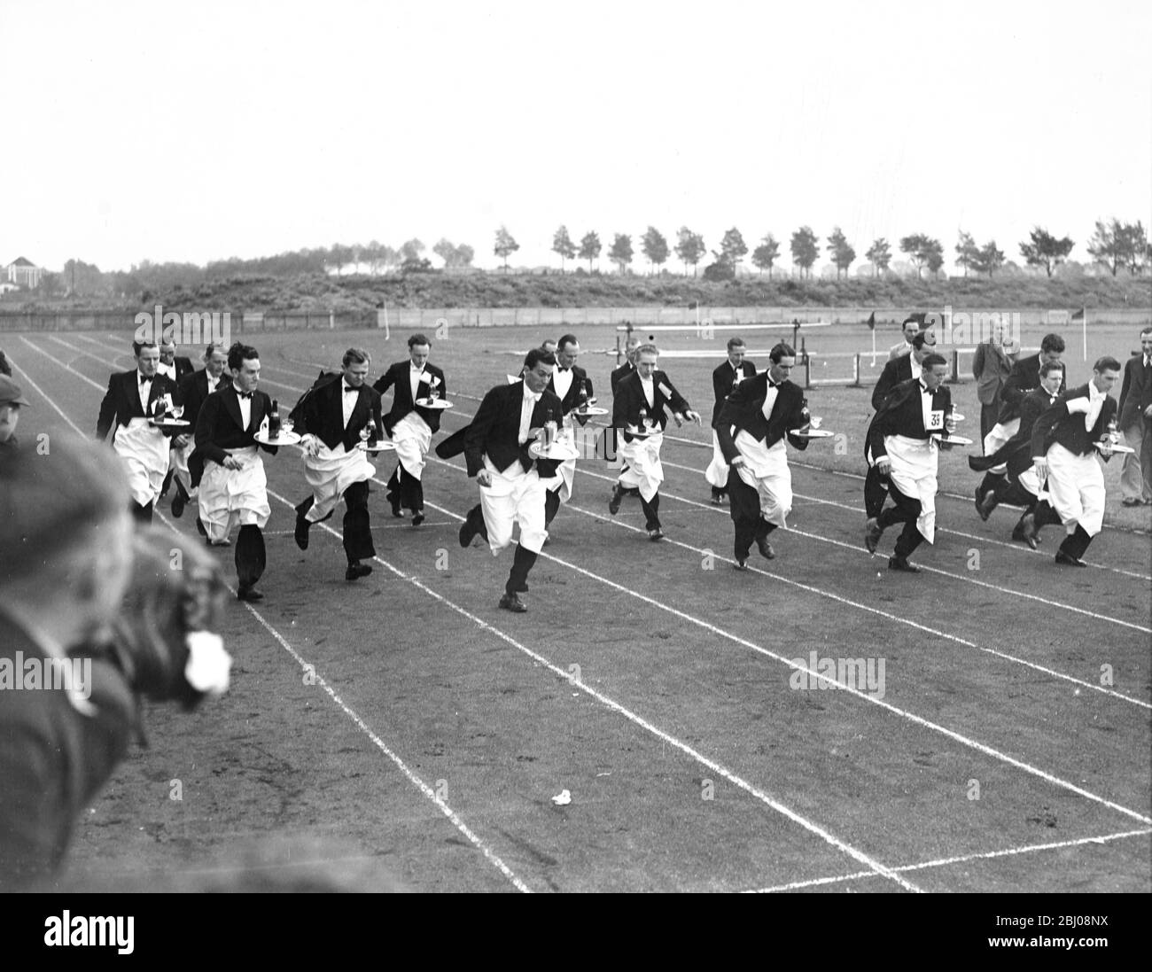 Pierre Gironde dopo il successo a Parigi vince la gara dei camerieri londinesi per le strade di Chiswick, terminando nello stadio del Politecnico mentre si trasporta un vassoio di champagne, qualsiasi fuoriuscita significa squalifica. - Chiswick, Londra, Inghilterra. - 20 maggio 1950 Foto Stock