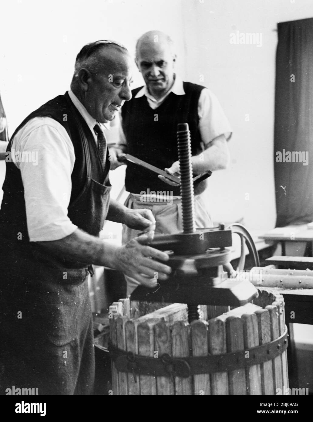 Foto mostra: Hambledon. Dopo la trivolatura, la miscela schiacciata viene pressata da Blackman, il maggiordomo di Salisbury-Jones. La resa di quest'anno dell'uva, dice Sir Guy, farà di Hambledon '57 la migliore annata di sempre. Foto Stock