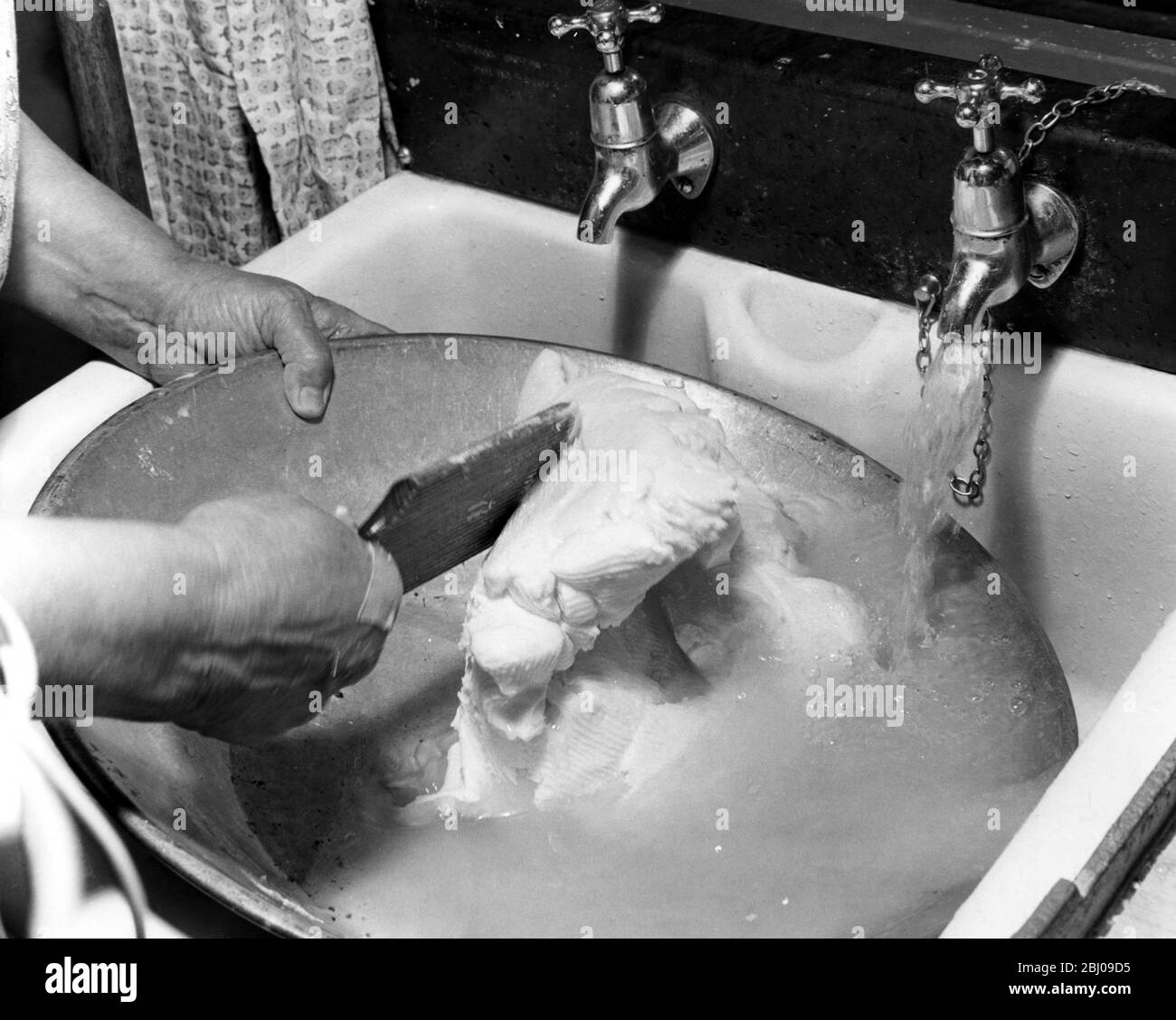 Miss Peggy Macleod lavaggio fuori la ciotola dopo aver fatto il burro a mano a Daliburgh South Uist Outer Hebridge Scozia - Settembre 1961 Foto Stock
