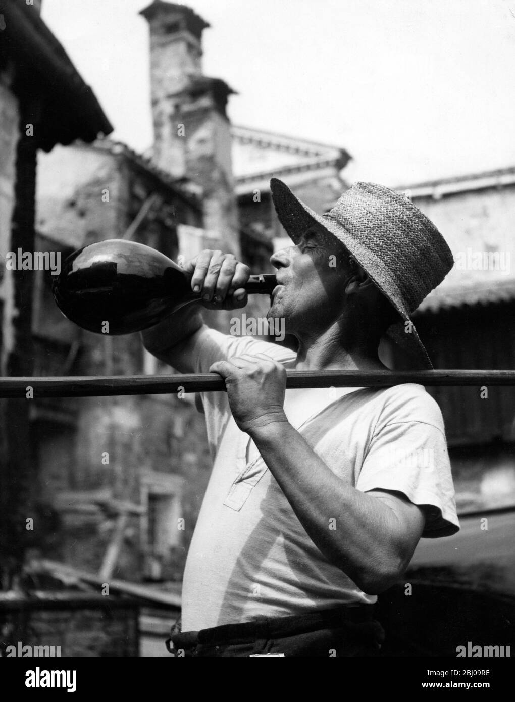 Un gondalier prende una bevanda da una bottiglia di vetro durante una giornata calda in Italia - 7 febbraio 1952 Foto Stock