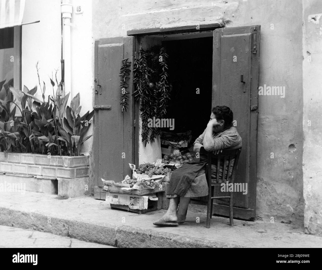 Un venditore di mercato con frutta e peperoncino nell'isola di Ischia vicino a Napoli - non datato Foto Stock