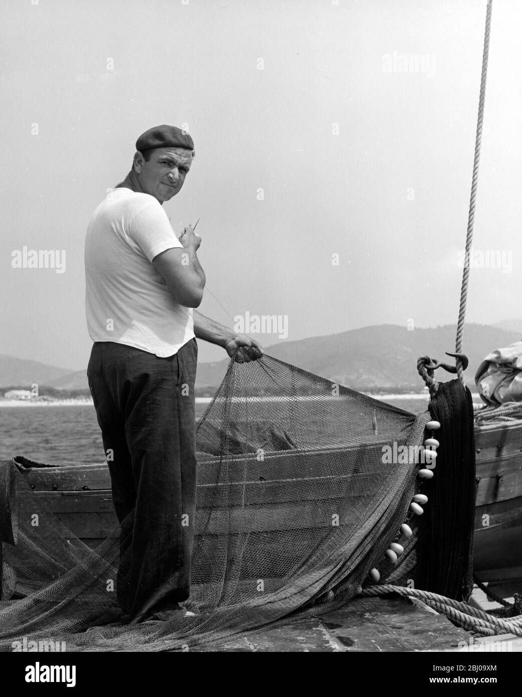Un pescatore Elbano che minaccia le reti - Marina di campo, Isola d'Elba, Italia - non datate Foto Stock