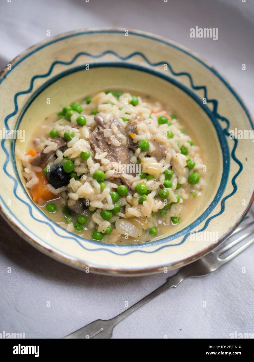 Risotto a base di avanzi di anatra selvatica brasati con olive. Foto Stock