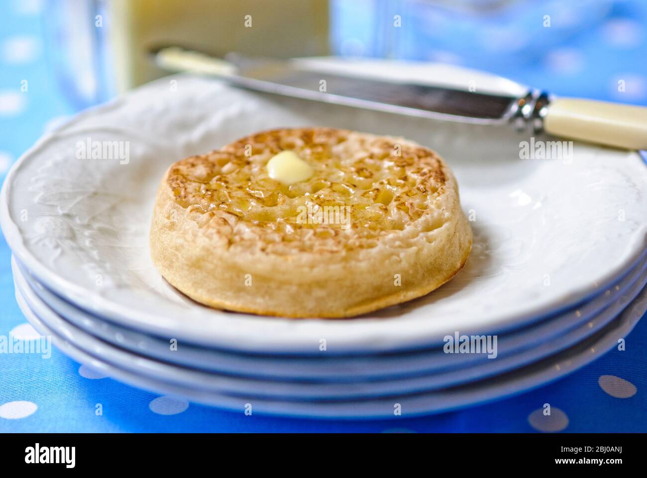 Crumpette al burro caldo su piatto bianco - Foto Stock