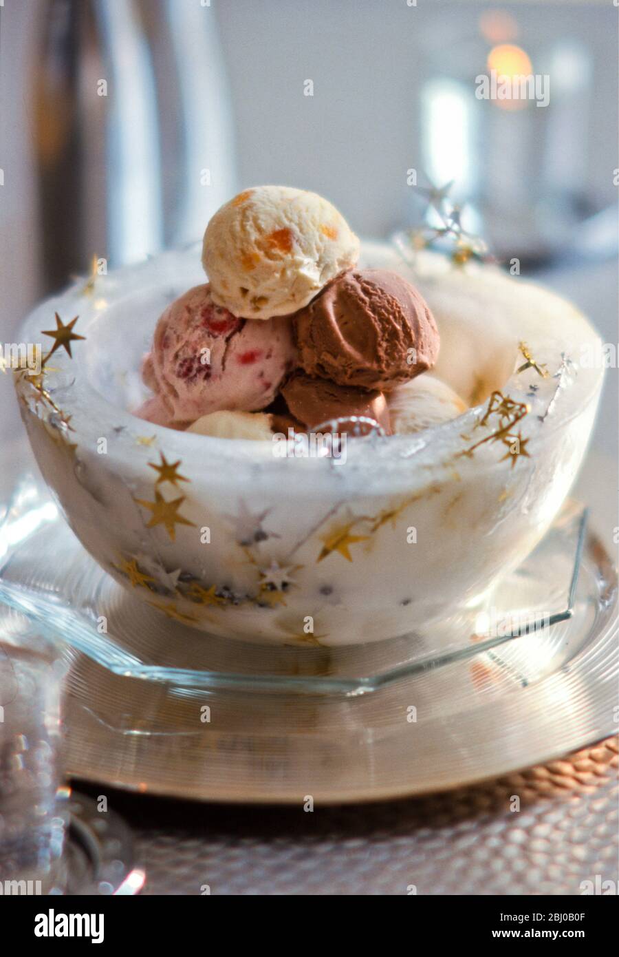 Ciotola di ghiaccio con stelle che tengono palle di gelato misto per festa di Natale - Foto Stock