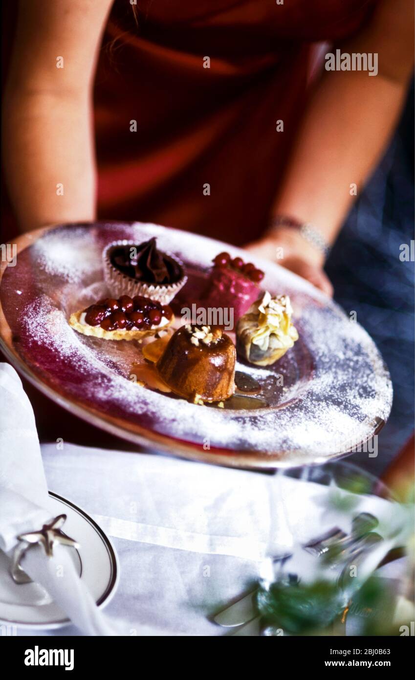 Selezione di dessert speciali per feste offerti su piatti rossi - Foto Stock