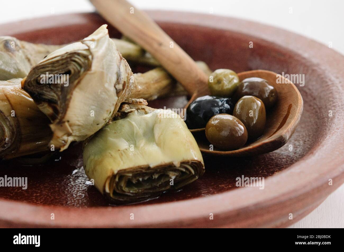 Carciofi italiani alla griglia e marinati su piatto marrone - Foto Stock
