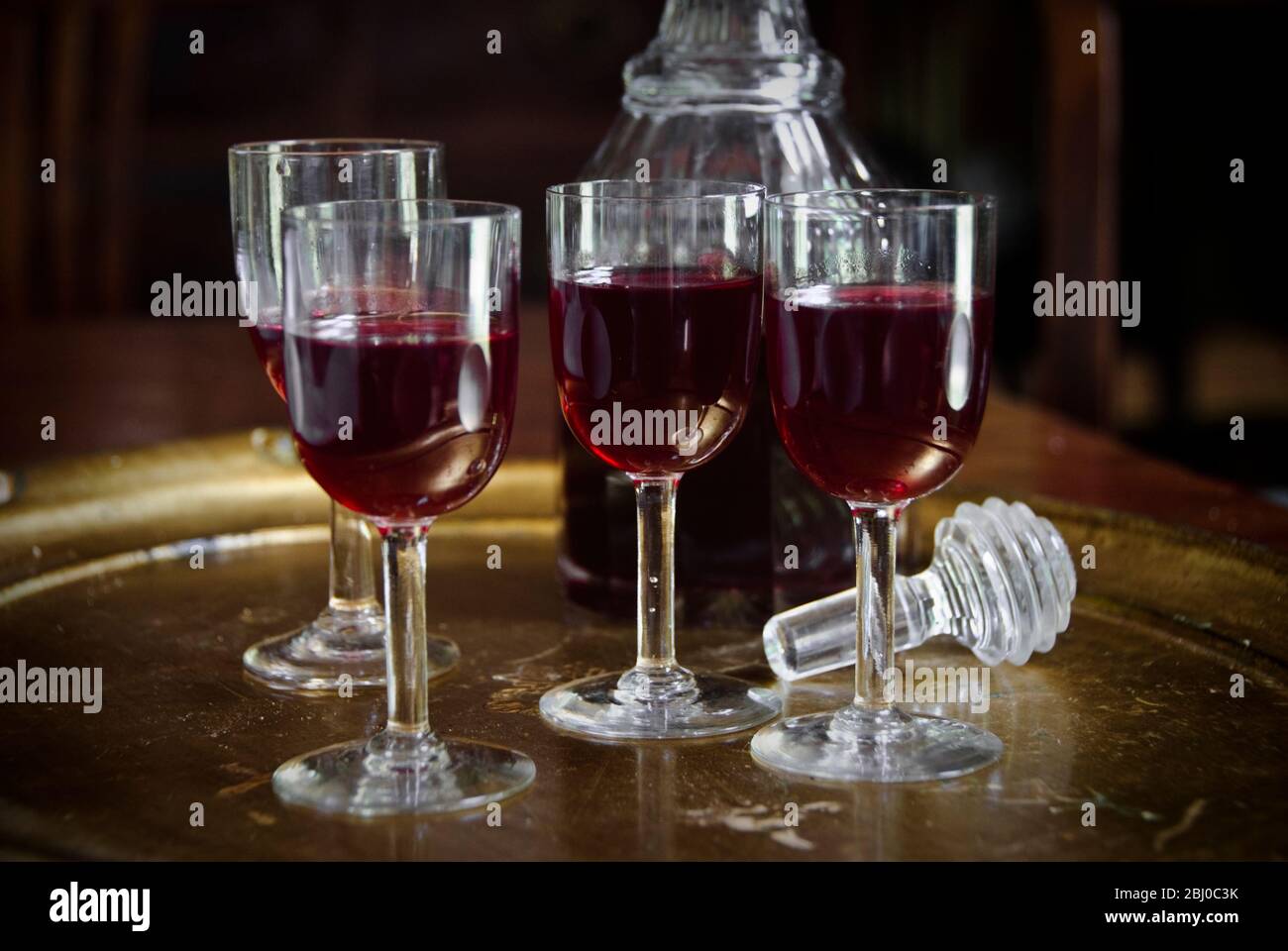 Vassoio di bicchieri di gin sloe con decanter senza tappo. - Foto Stock