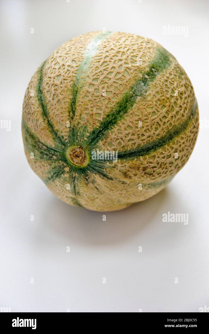 Melone di cantaloupe intero su superficie bianca - Foto Stock