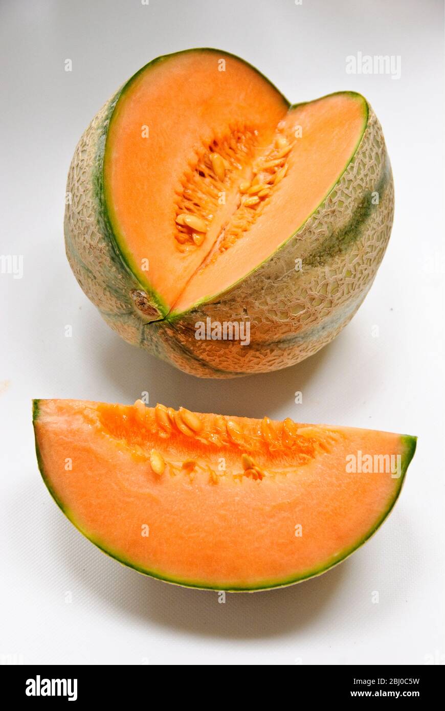 Melone cantaloupe con sezione tagliata su fondo bianco - Foto Stock