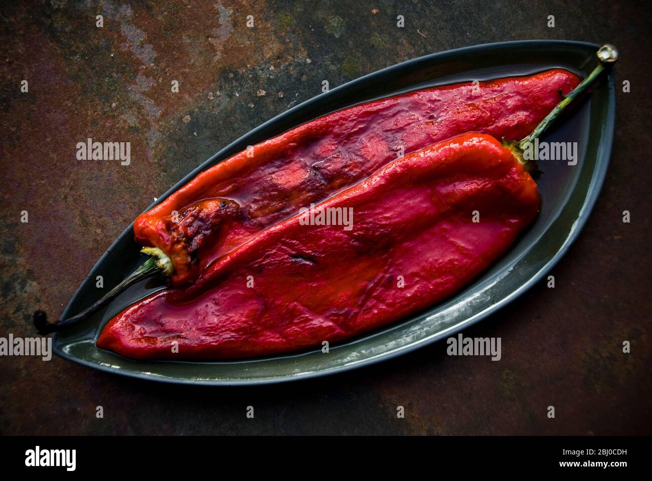 Peperoni rossi alla griglia con bucce vescicate rimosse - Foto Stock