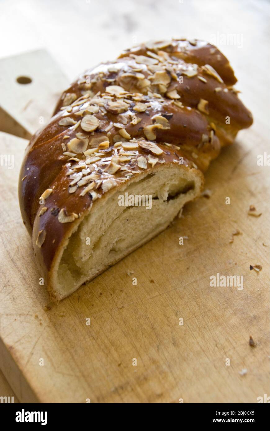 Pezzo di pane dolce, lievito con mandorle e pasta di mandorle su legno - Foto Stock