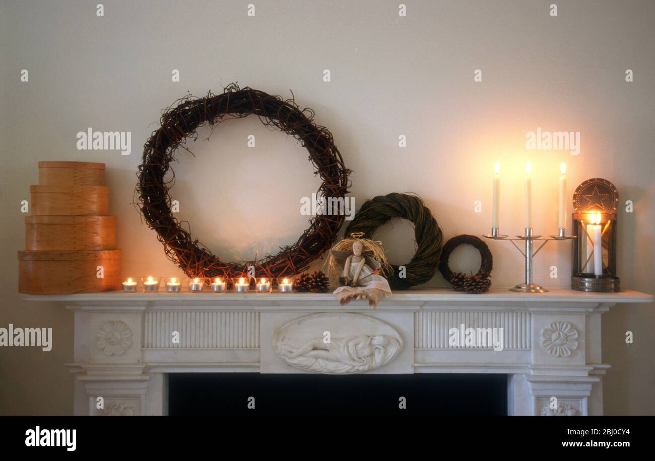 Pezzo di camino in interni pallidi con decorazioni e oggetti in stile chritmas shaker - Foto Stock