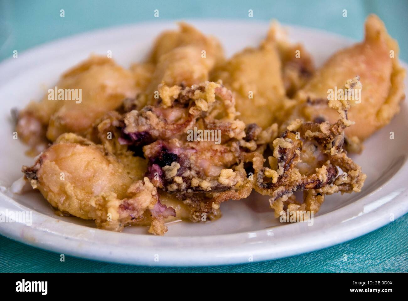 Calamari fritti profondi in una pastella leggera, parte di una meze in un ristorante di pesce greco-cipriota sul lungomare di Larnaca, Cipro meridionale - Foto Stock