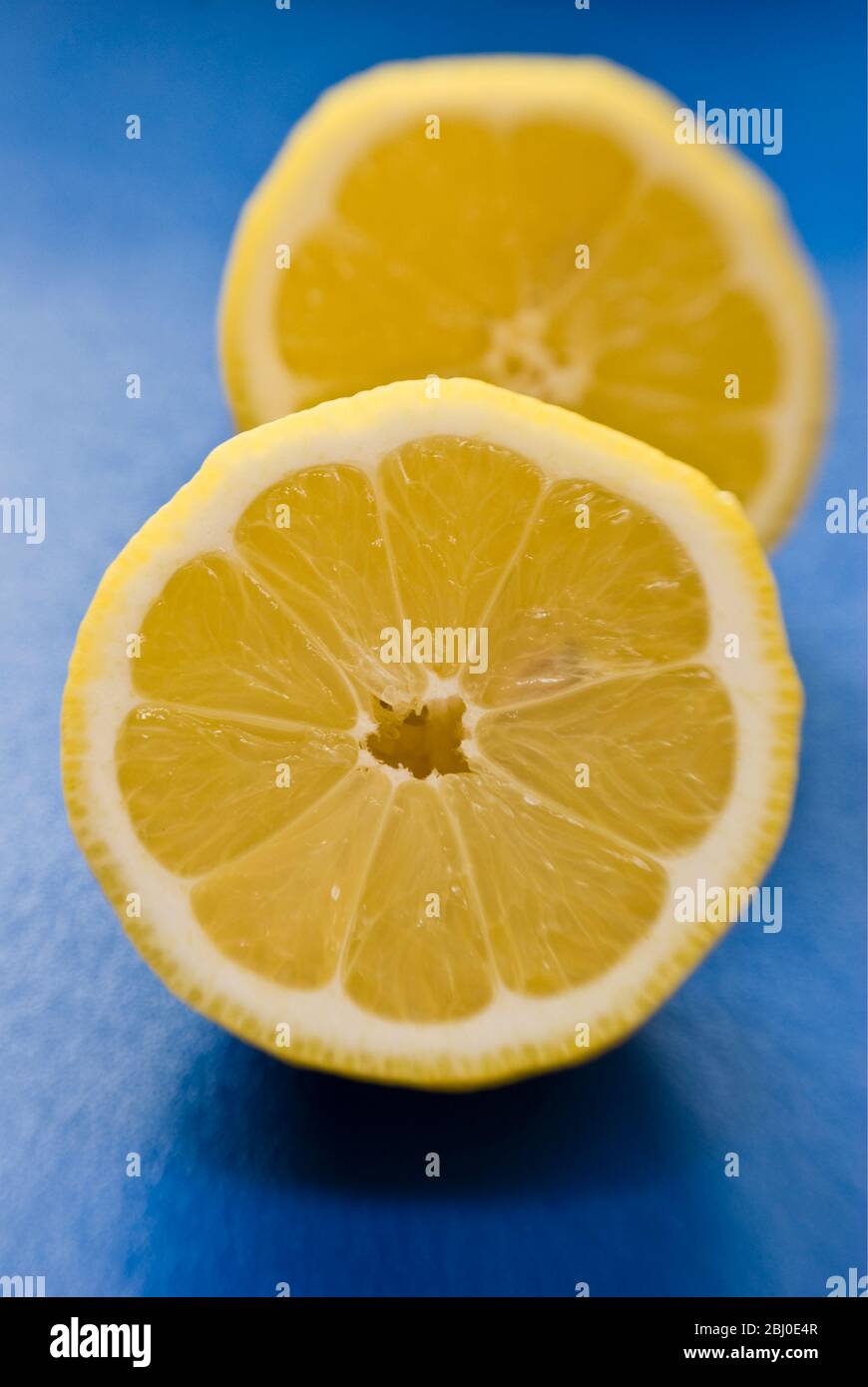 Limone a metà su superficie blu - Foto Stock