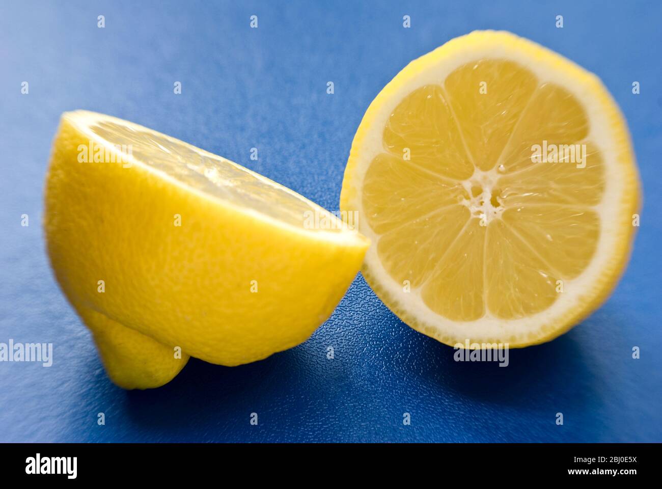 Limone a metà su superficie blu - Foto Stock