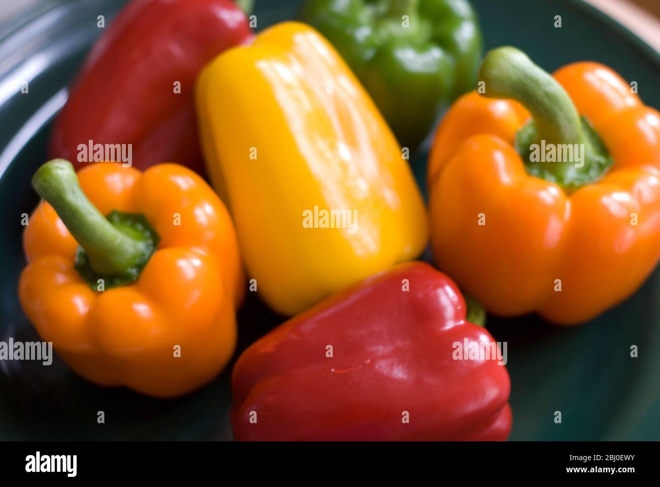 Selezione di peperoni dolci in resh lucido su piastra verde - Foto Stock