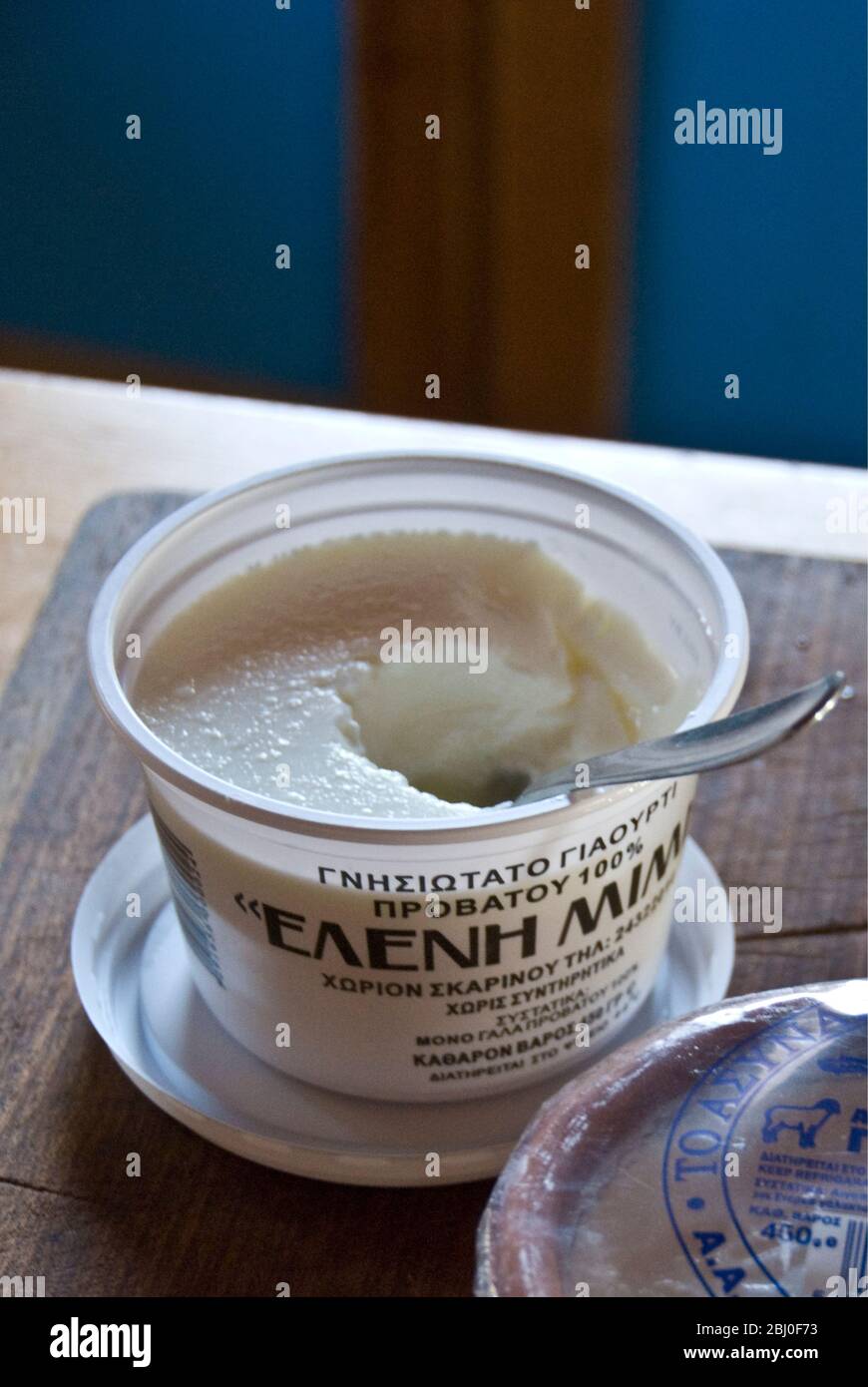 Cartone di plastica di Greek set latte di vacca yogurt su banco cucina in casa cipriota - Foto Stock