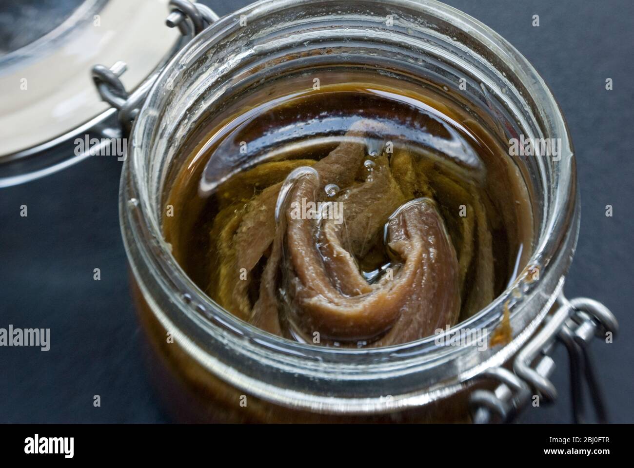 Filetti di acciughe in olio in vasetto di conservazione. - Foto Stock