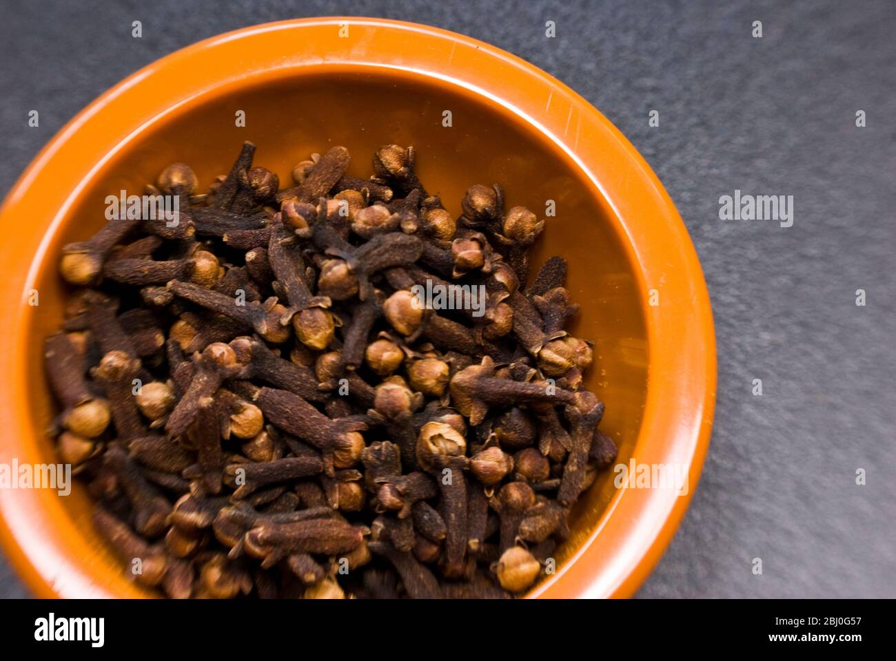 Una ciotola piccola di chiodi di garofano secchi interi - Foto Stock