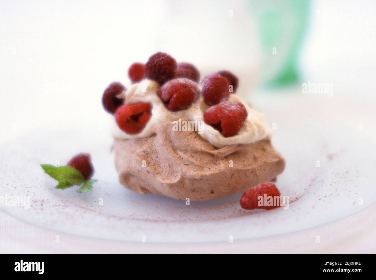 Meringa al cioccolato con panna montata e lamponi freschi - Foto Stock
