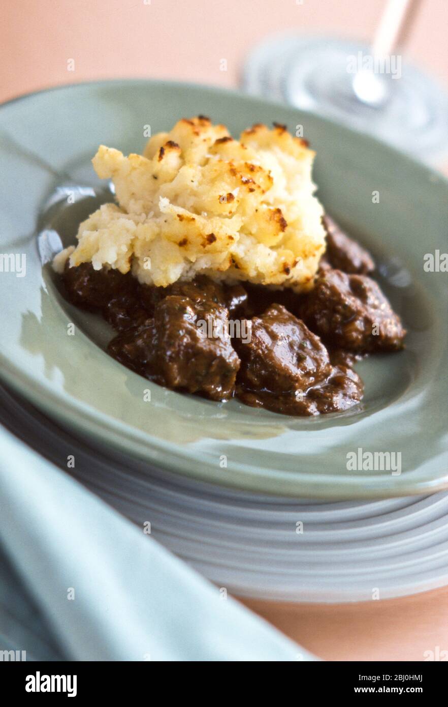 Brasato di manzo con purè di patate alla griglia, su piatto verde. - Foto Stock