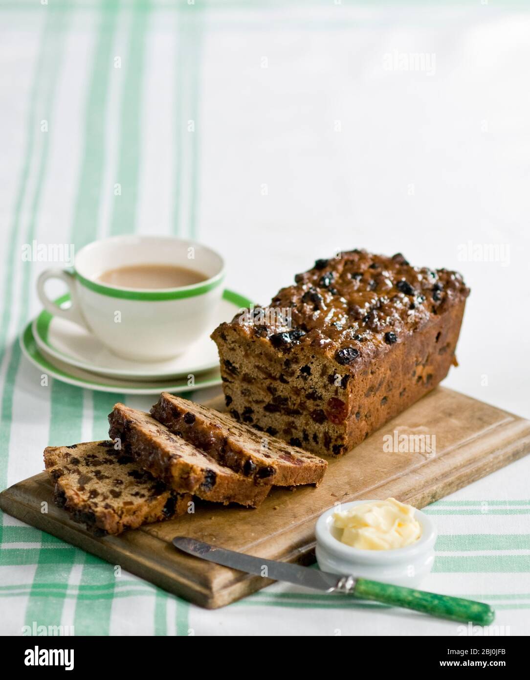 Tradizionale pane di frutta in stile affettato e servito con burro e tè pomeridiano - Foto Stock