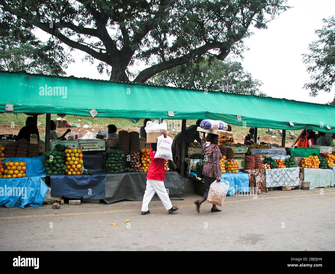 Mercato ortofrutticolo a Nelspruit - Mpumalanga, Sudafrica, con persone che trasportano merci sulla testa - Foto Stock