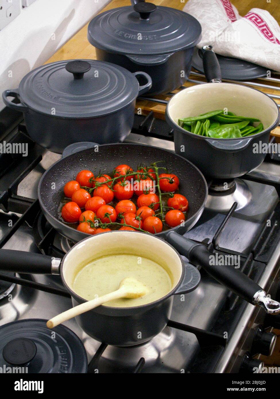 Cucina piano cottura in corso con selezione di ghisa pesante pentole le Creuset - Foto Stock