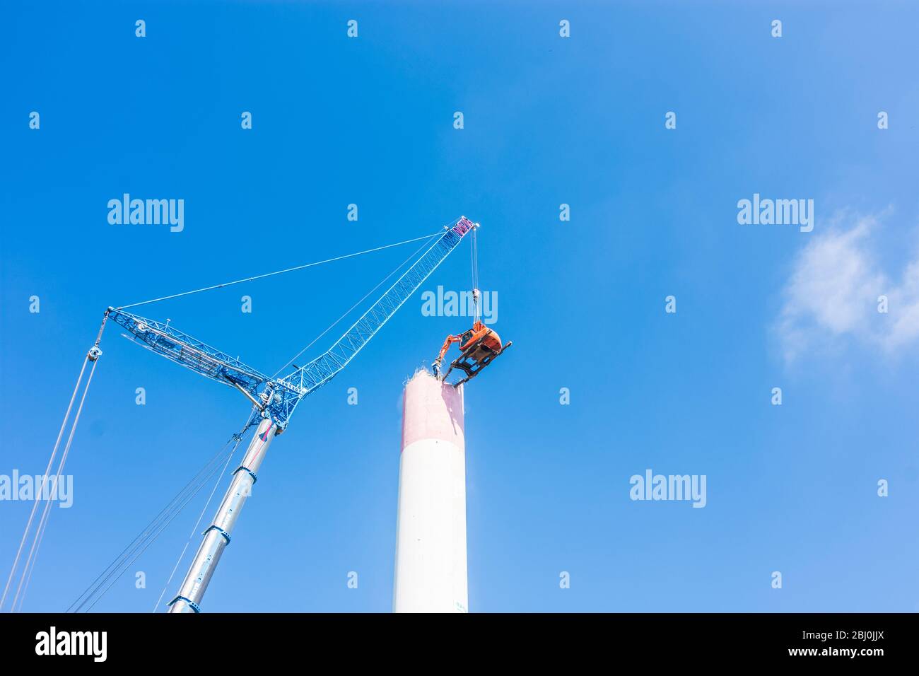Vienna: Demolizione del camino dell'impianto di riscaldamento urbano di Kagran che non è più utilizzato con un 'escavatore volante'. Le macerie finiscono in essi Foto Stock