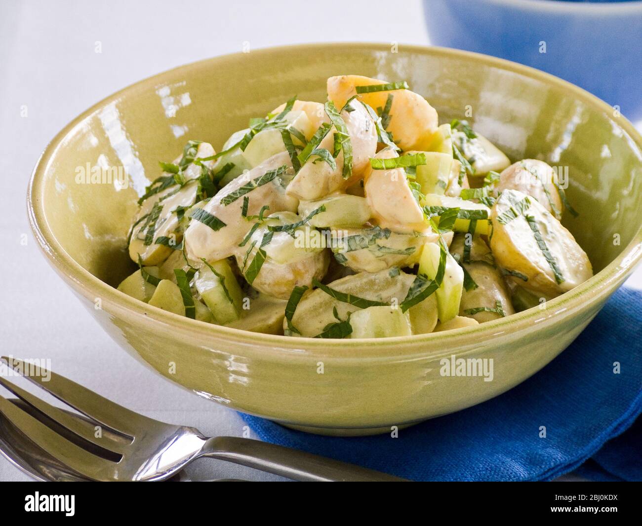 Insalata di patate con condimento cremoso e menta in terrina verde - Foto Stock