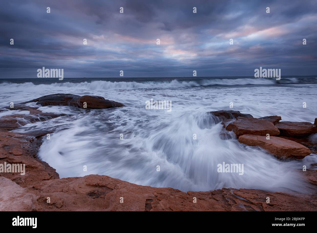 Cielo nuvoloso, onde grandi, paesaggio nuvoloso appena prima della tempesta vicino alla riva Foto Stock