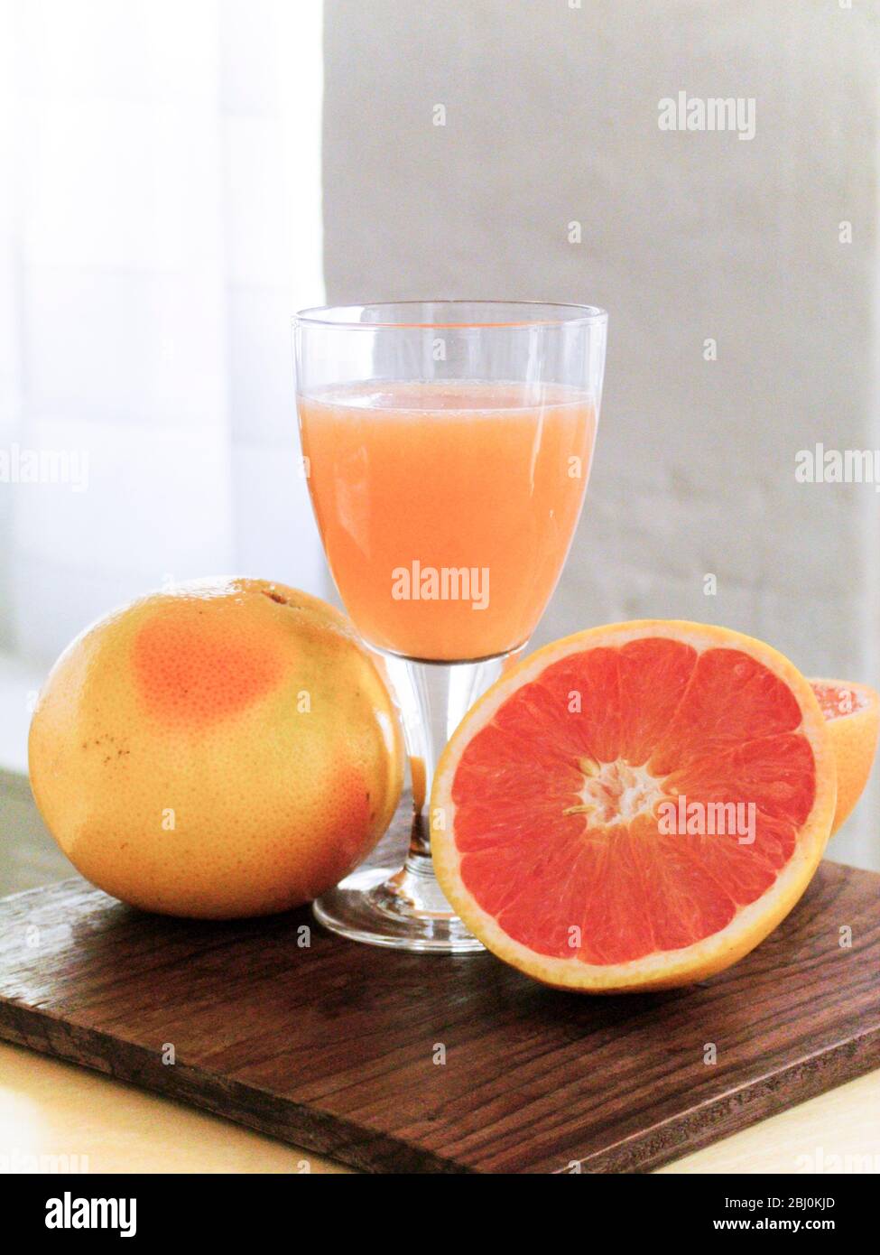 Pompelmo rosa con bicchiere di succo di pompelmo - Foto Stock