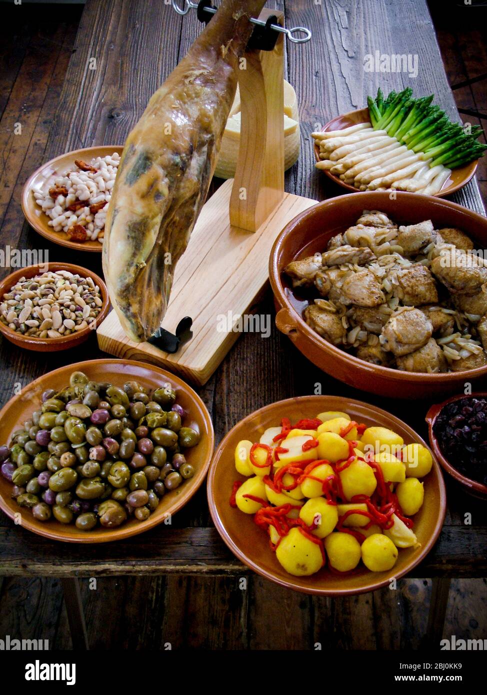 Tavolo a buffet di piatti spagnoli, incluso jamÑn iberico, su speciale stativo di intaglio - Foto Stock