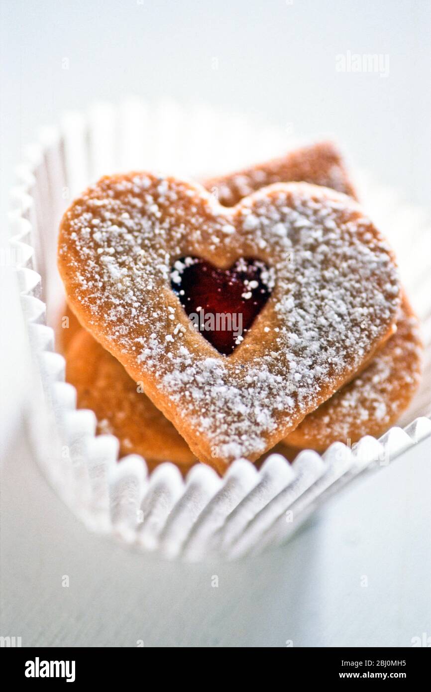 Graziosi biscotti a forma di cuore in muffin di carta bianca case9 - Foto Stock